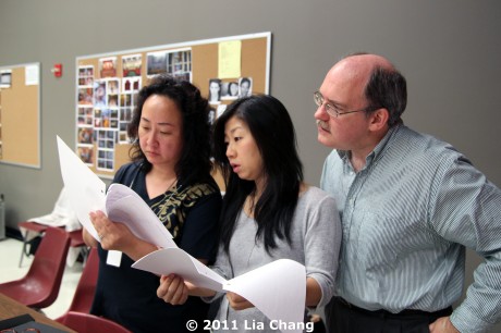 Translator Candace Chong (center) reviews the Chinese dialogue in the new script pages with Joanna C. Lee and Ken Smith, Cultural Advisors for Chinglish, in the Healy Room of the Goodman Theatre in Chicago on June 5, 2011. © 2011 Lia Chang