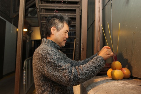 Playwright David Henry Hwang places incense in the altar for good fortune. Photo by Lia Chang